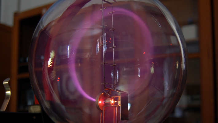 Electrons produce cyclotron radiation as they are manipulated by magnetic fields.